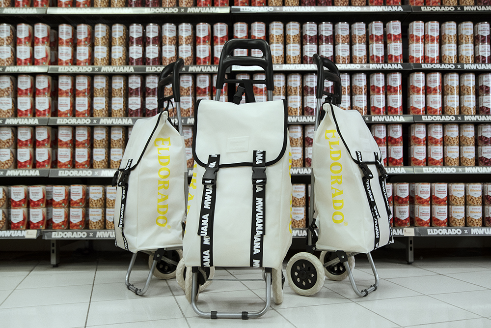 Vita dramatenväskor framför hylla med konservburkar