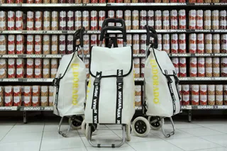 Vita dramatenväskor framför hylla med konservburkar