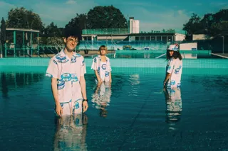 Män och kvinnor står i pool med rosa kläder