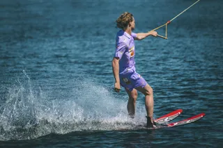 Man åker vattenskidor i lila kläder