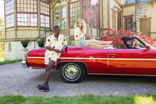 Man och kvinna står vid röd bil